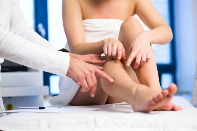 El médico examina las piernas en busca de venas varicosas.